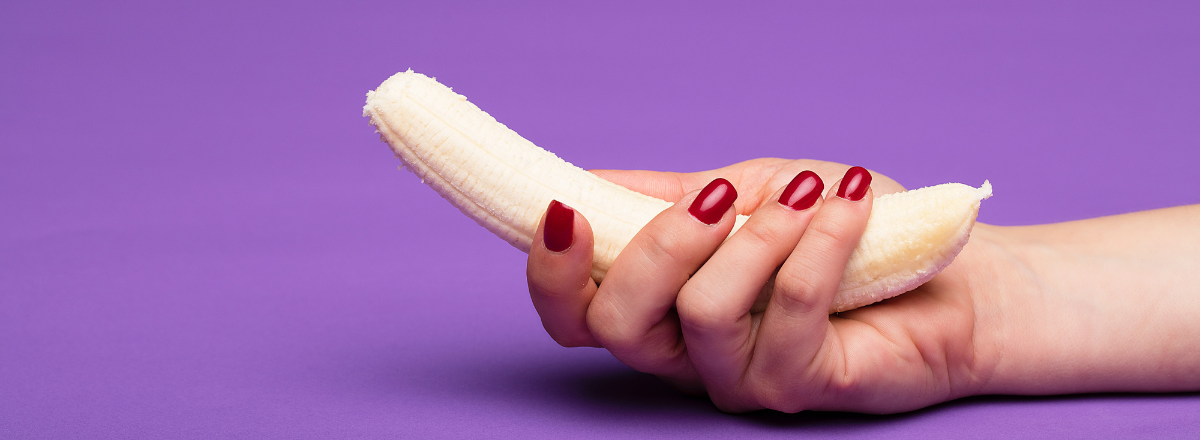 kvindehånd, der holder en skrællet banan