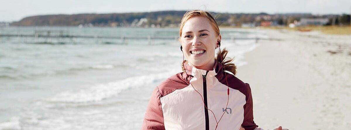 Kvinde på strand med lydbog